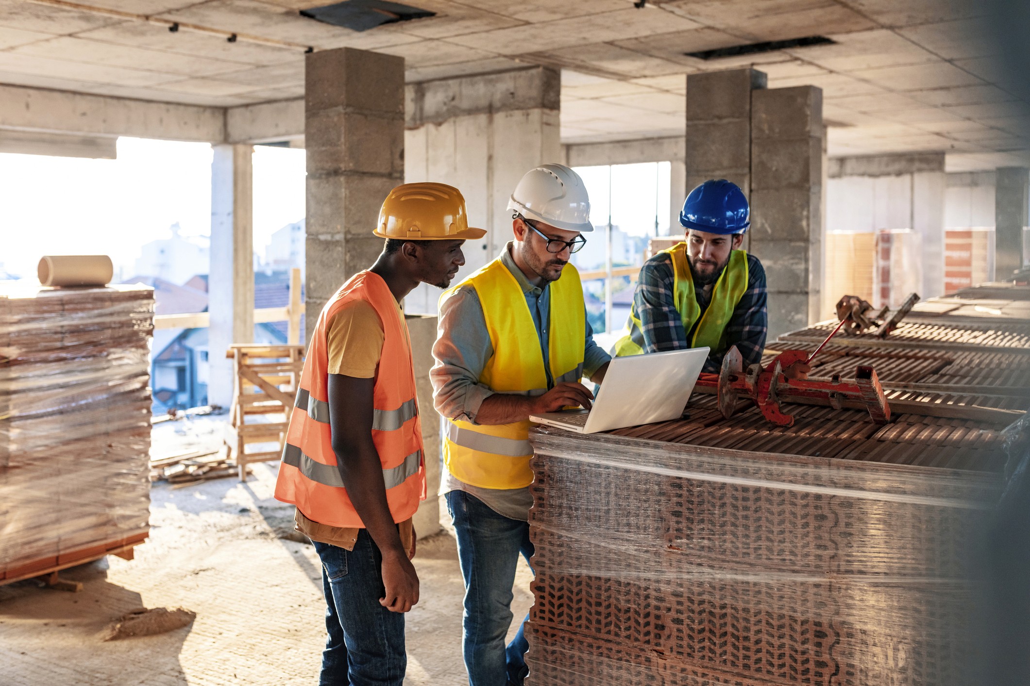 Construction workers review plans at a job site.