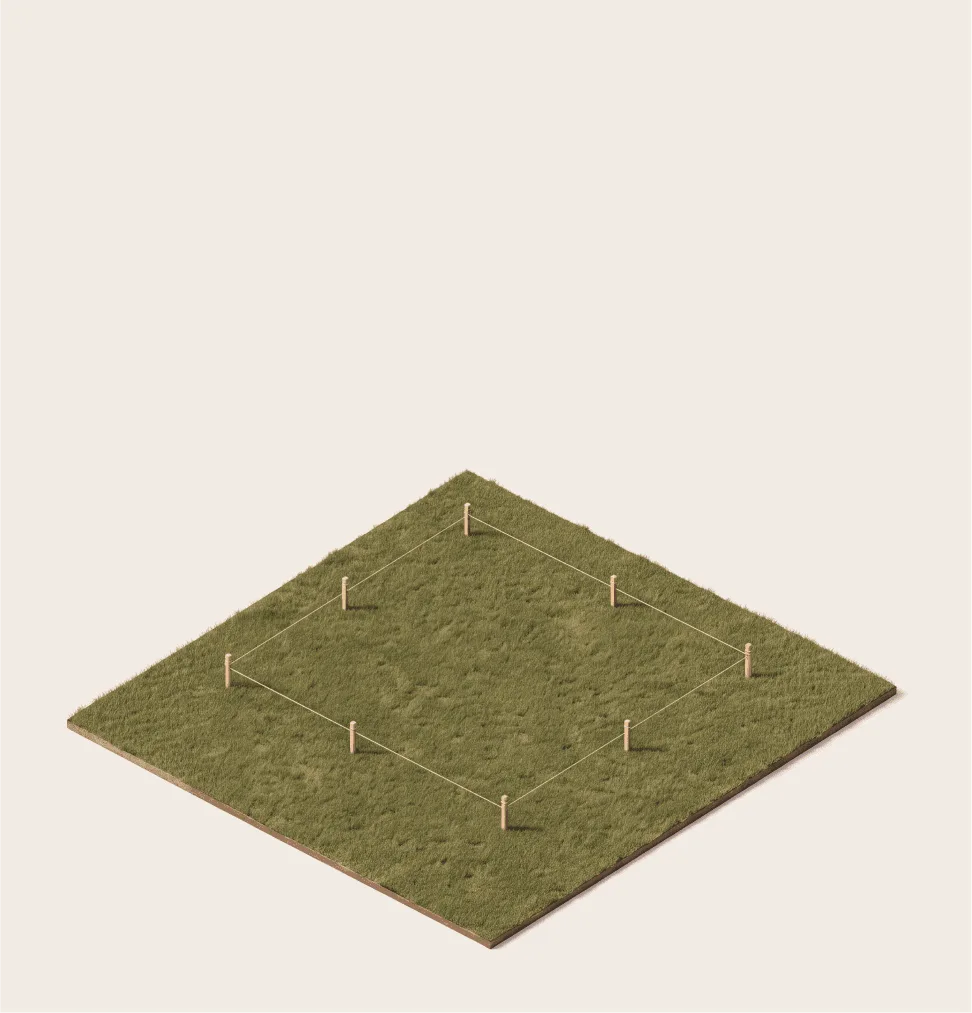 Empty grassy plot marked with survey stakes and string, outlining the future footprint of a home.