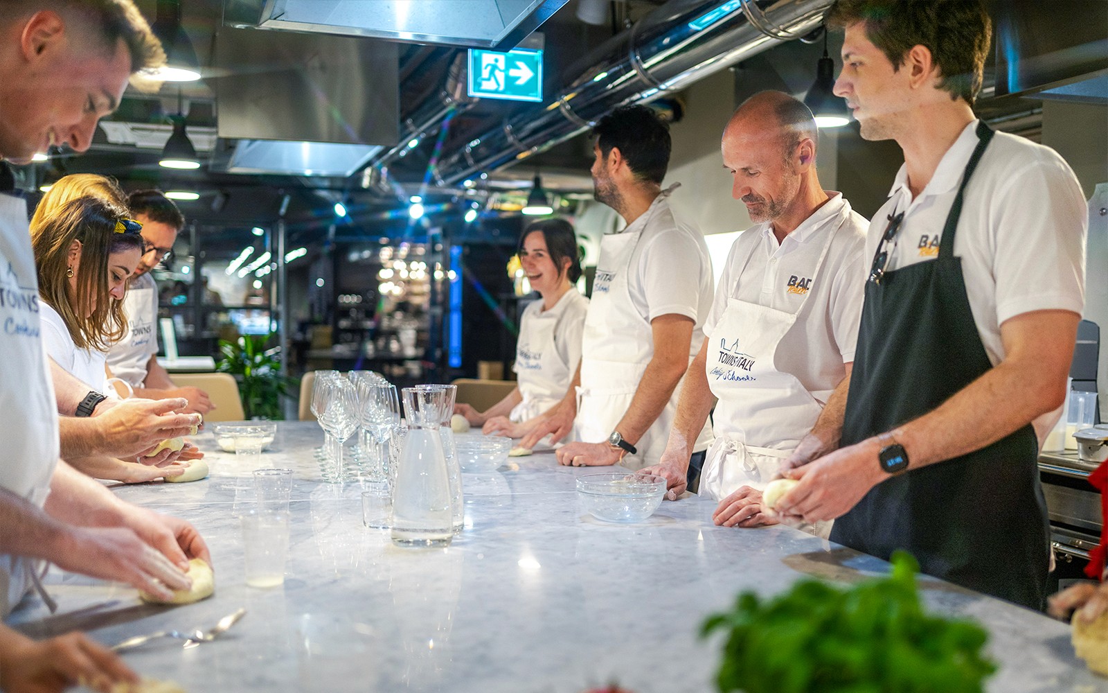 Participants kneading dough during a gelato and pizza making class in Milan.