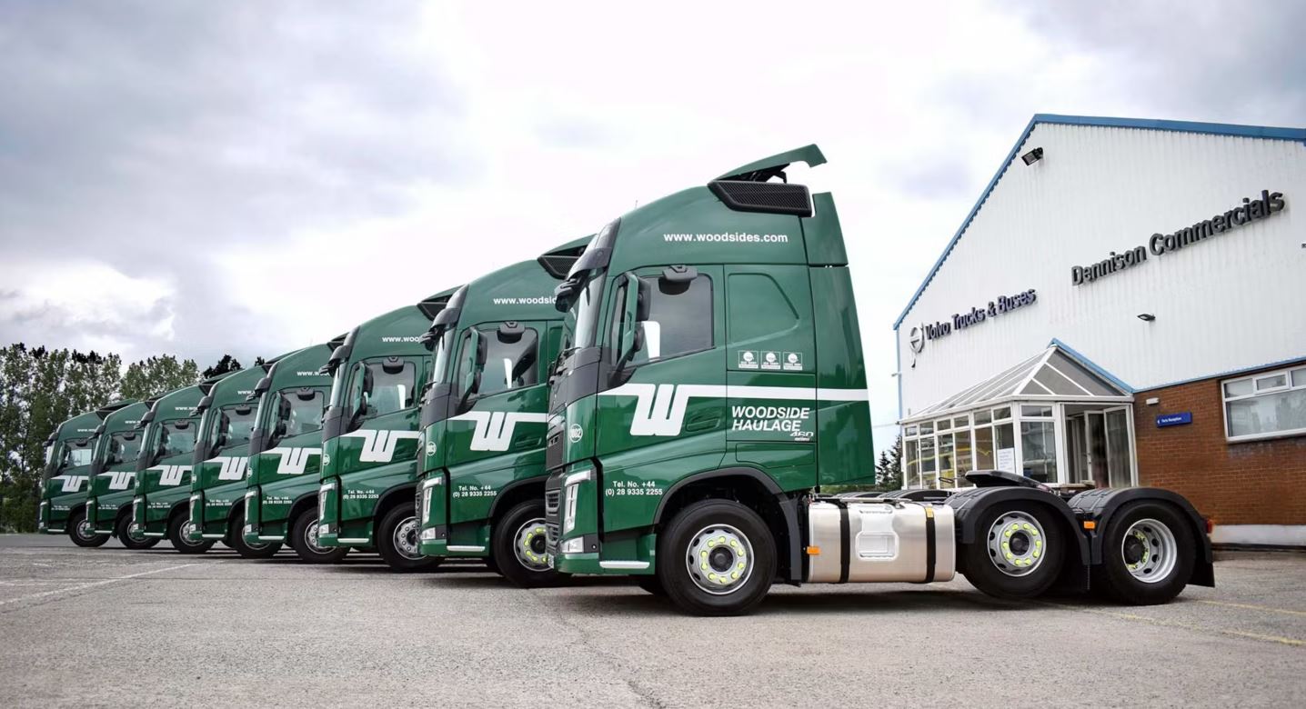 Woodside Logistics trucks driving on a road, representing the company's role in expanding Palletforce's logistics coverage