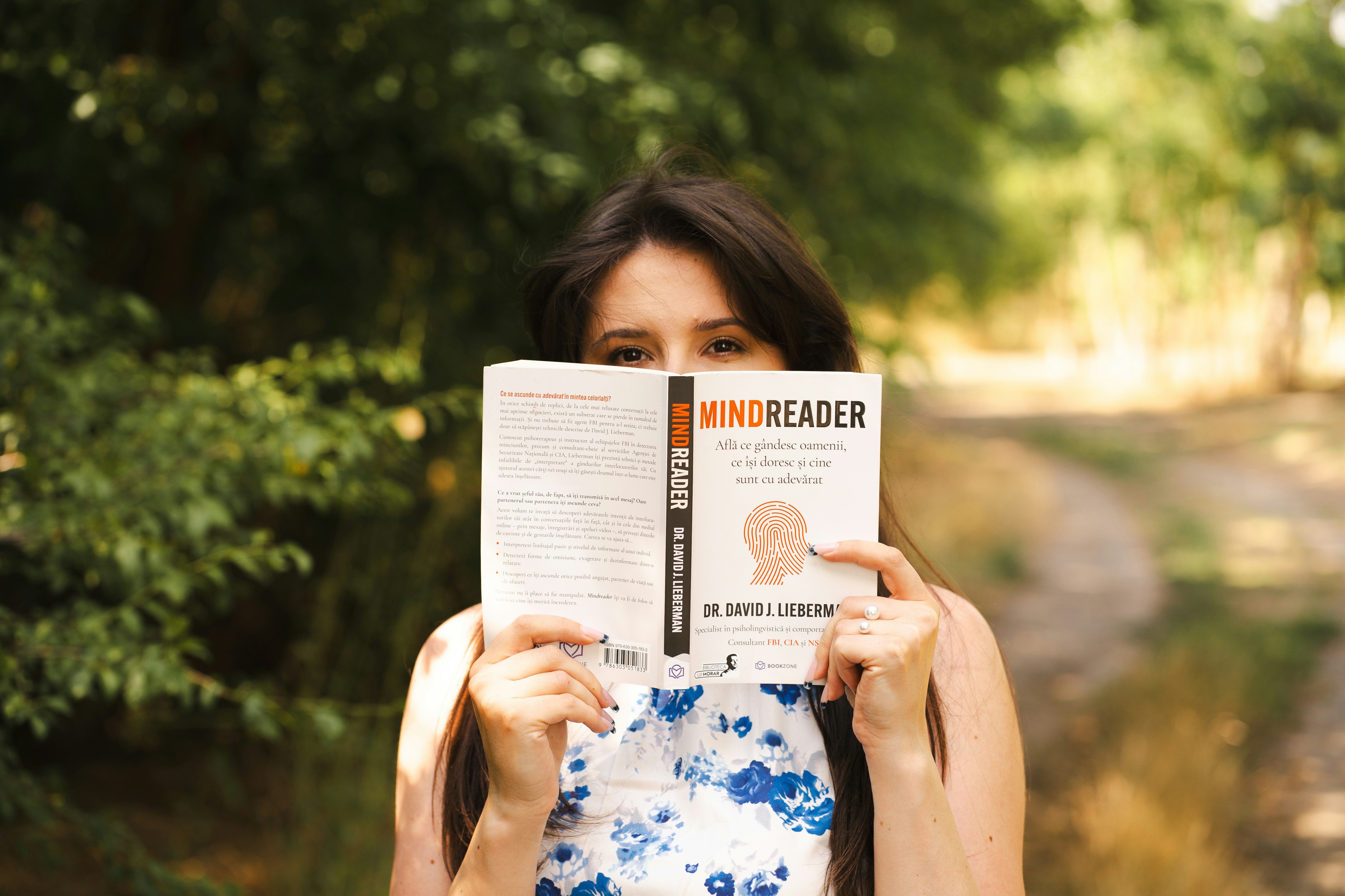 Woman holds a book titled "mindreader."