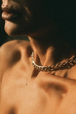 closeup of a gold curb chain necklace