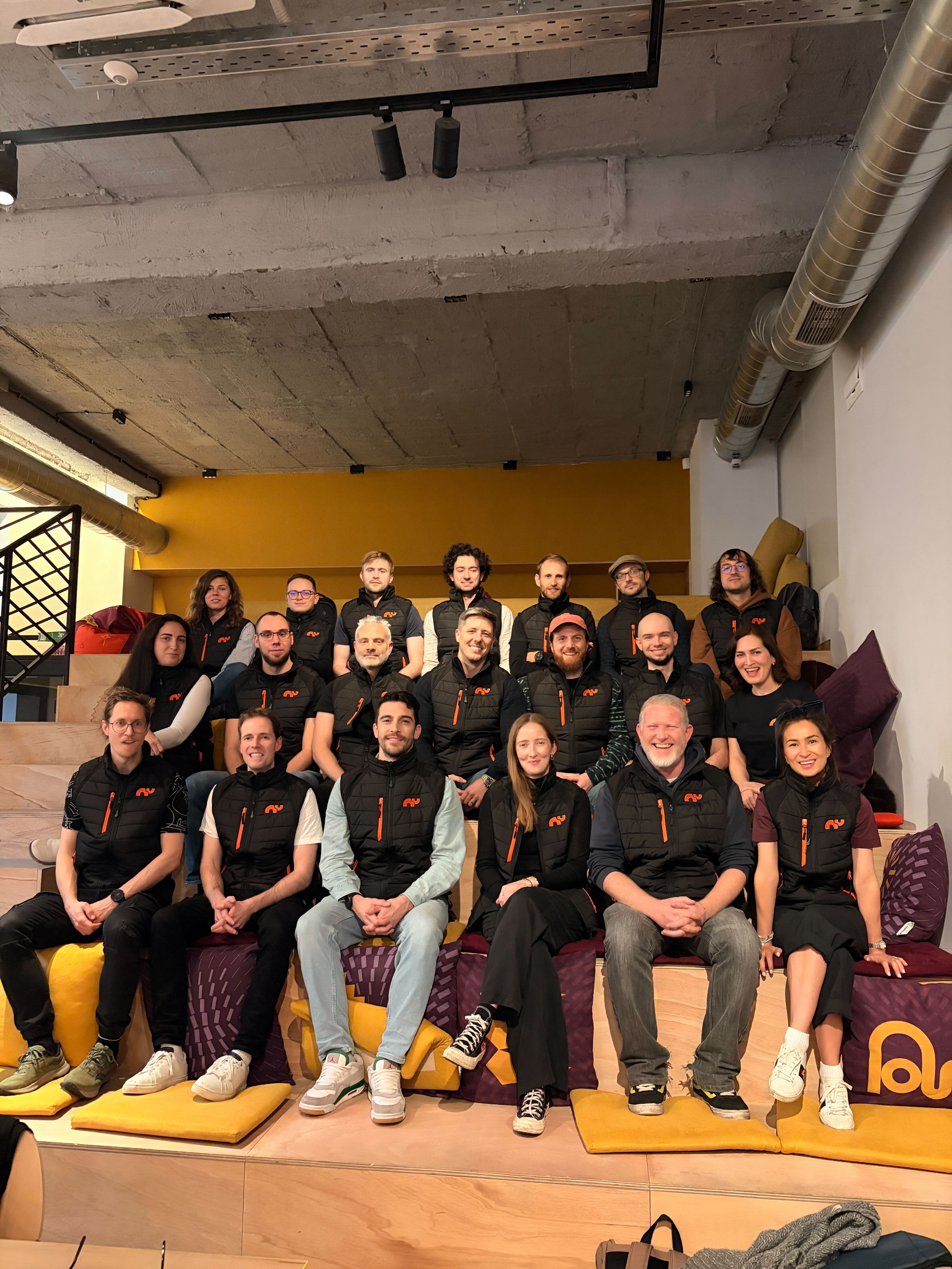 The Rhino.fi team posing in front of decorated cars during an outdoor team event