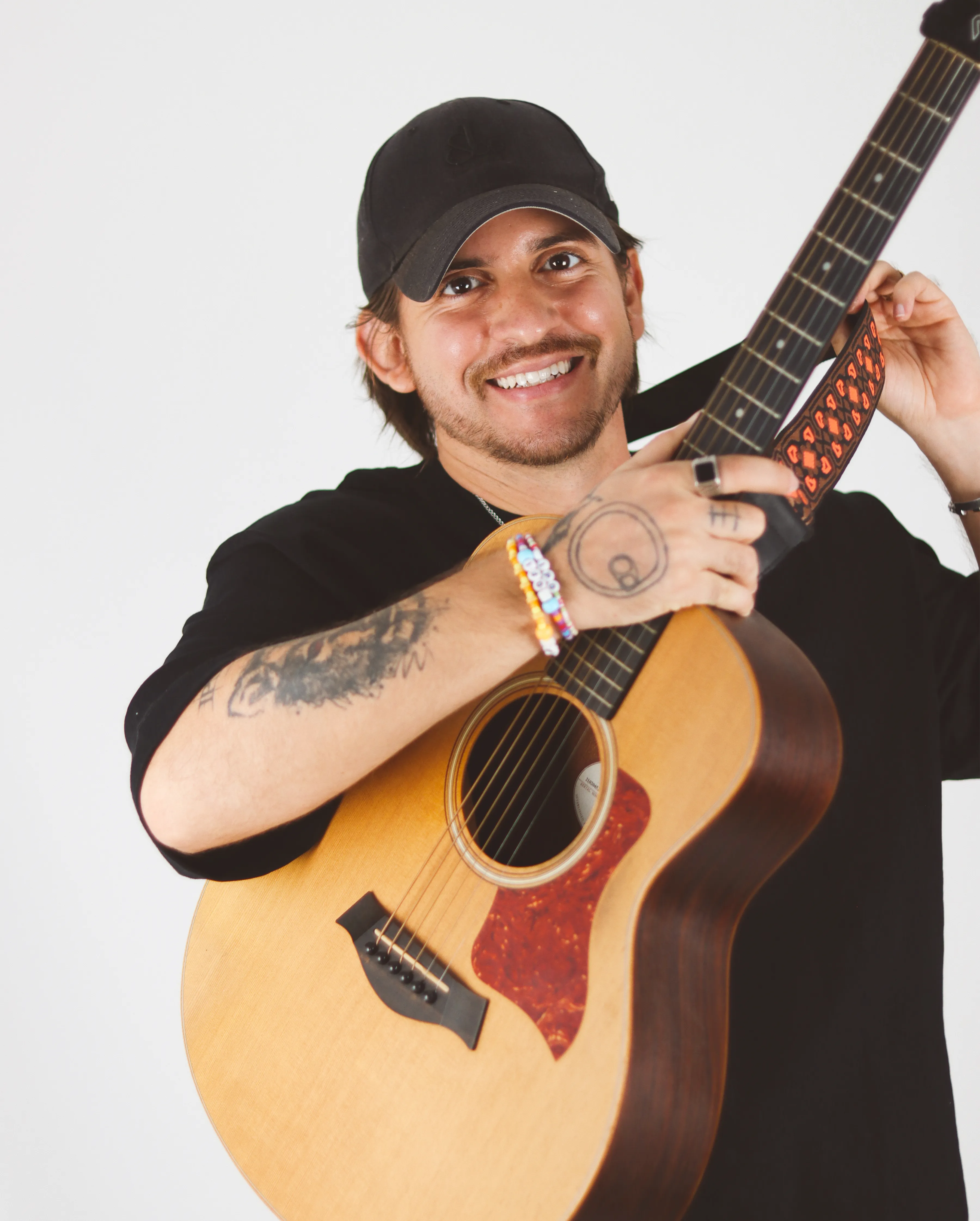Retrato de artista sosteniendo guitarra y sonriendo