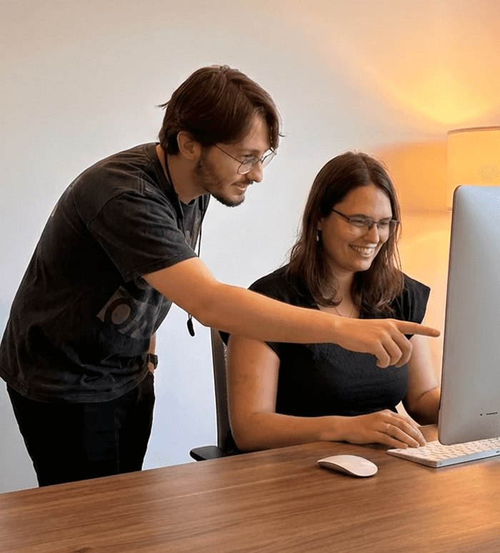 Woman in brown leather jacket posing against a coastal backdrop.