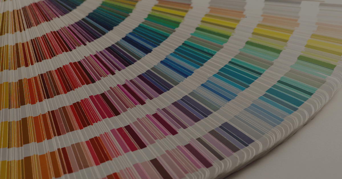 A fanned out paint chip book with a rainbow of colours.