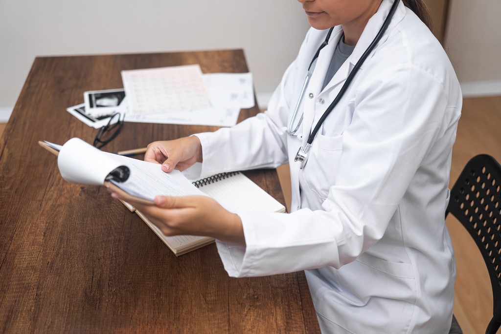 therapist doctor studies patient documents and results during consultation