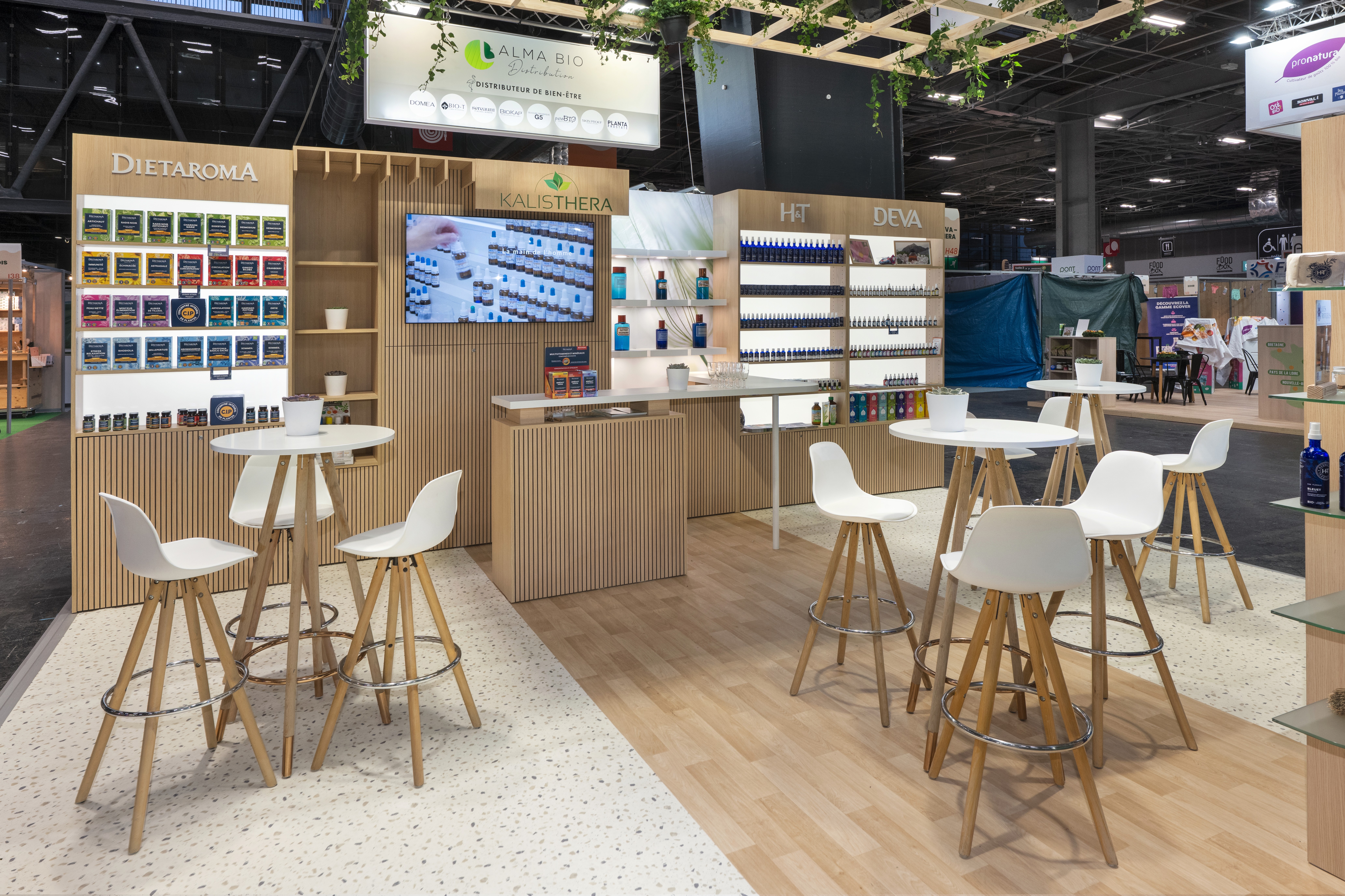 Stand Alma Bio Distributeur Natexpo 2025 – espace convivialité et échange avec tables hautes, stand professionnel réalisé par Expace
