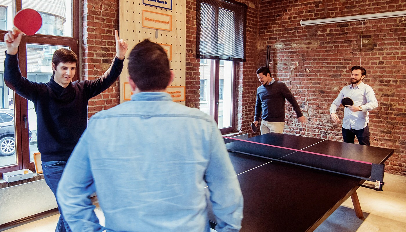 Younf employees playing table tennis