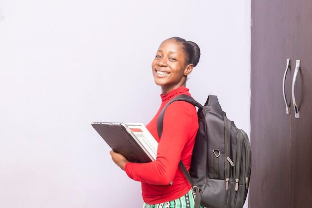 Smiling young man with short hair poses against a dark background, wearing a green button-up shirt.