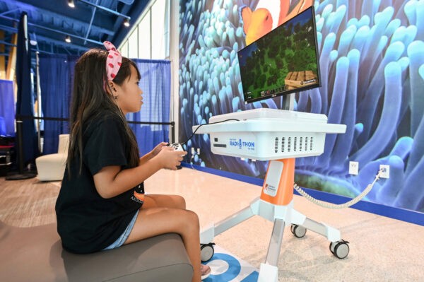 Patient playing Minecraft on a Gamers Outreach Kart with a Turtle Beach controller.
