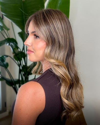 A close-up of hands performing a relaxing massage, with warm golden light illuminating the skin. The scene evokes a sense of relaxation and well-being.