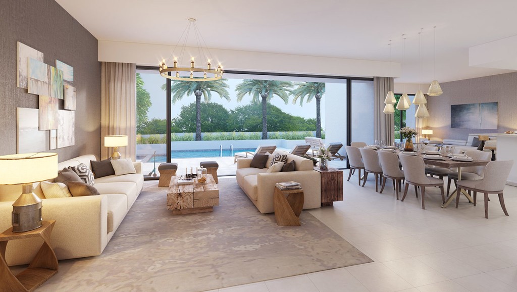 Contemporary living room with white furnishings and a kitchen area, located in Sidra Villas.