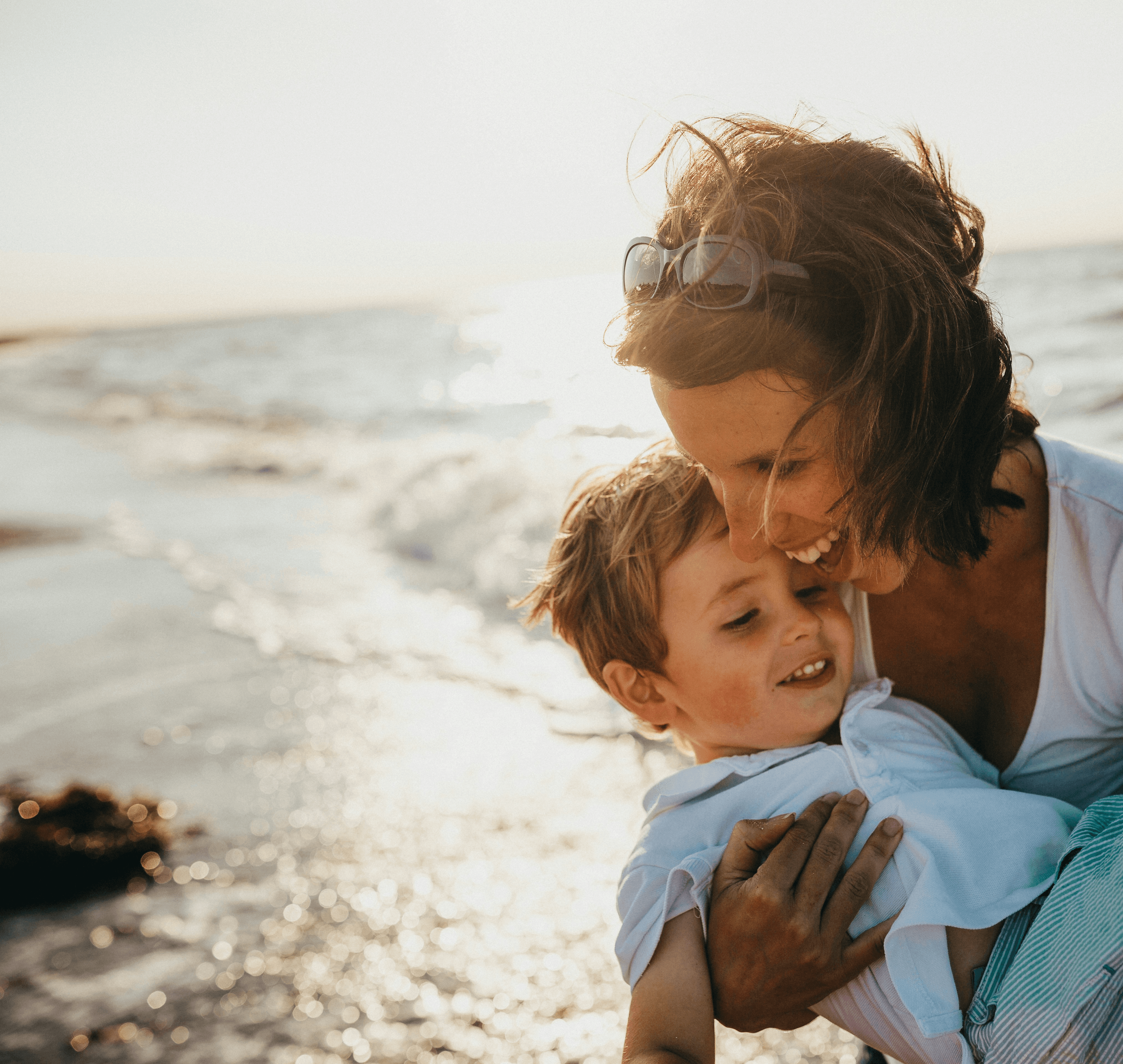 photo of mother and child beside body of water