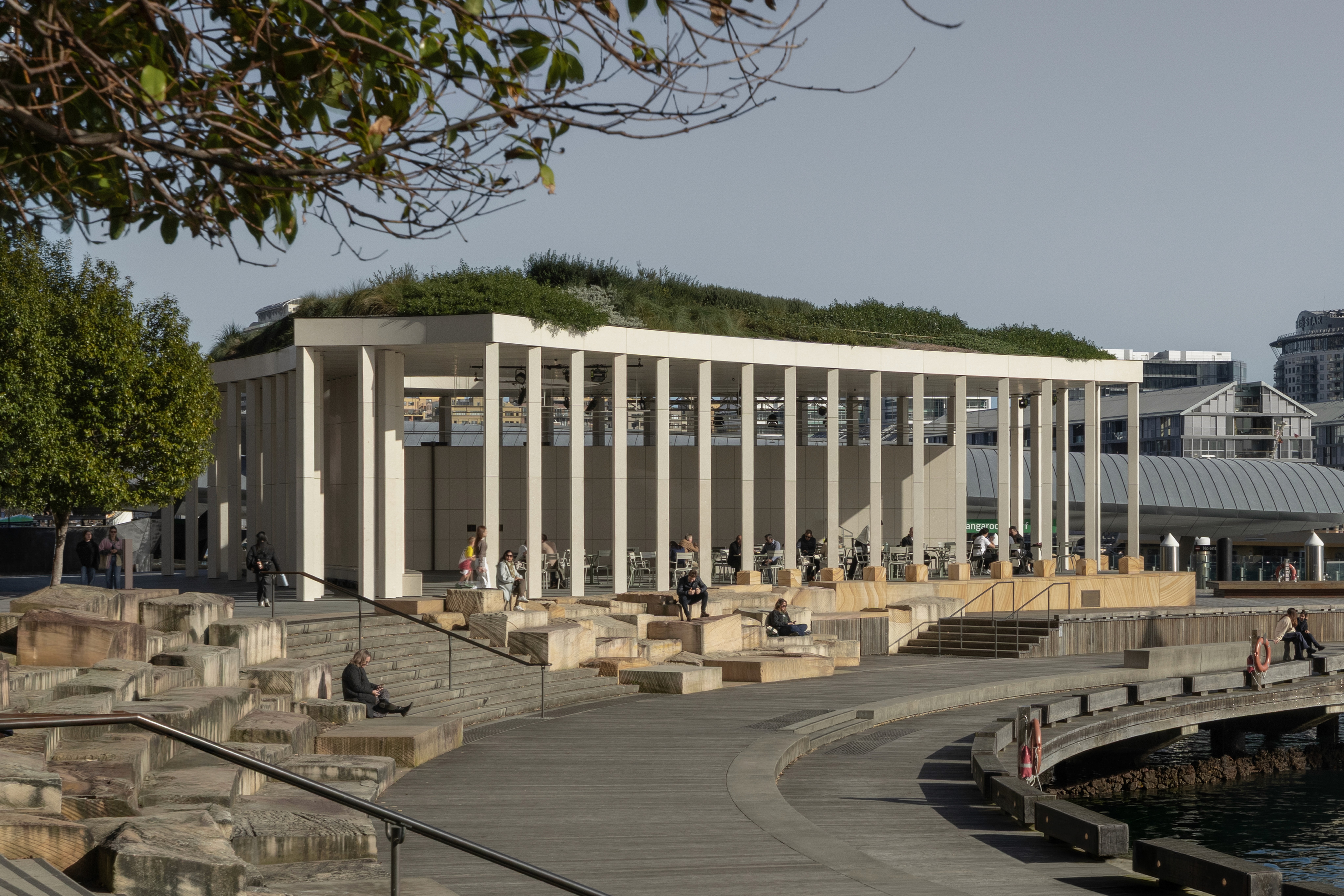 Read against the openness of Sydney Harbour, the pavilion's restrained geometry becomes less of an isolated object than a quiet civic marker, framing public life without competing for attention.
