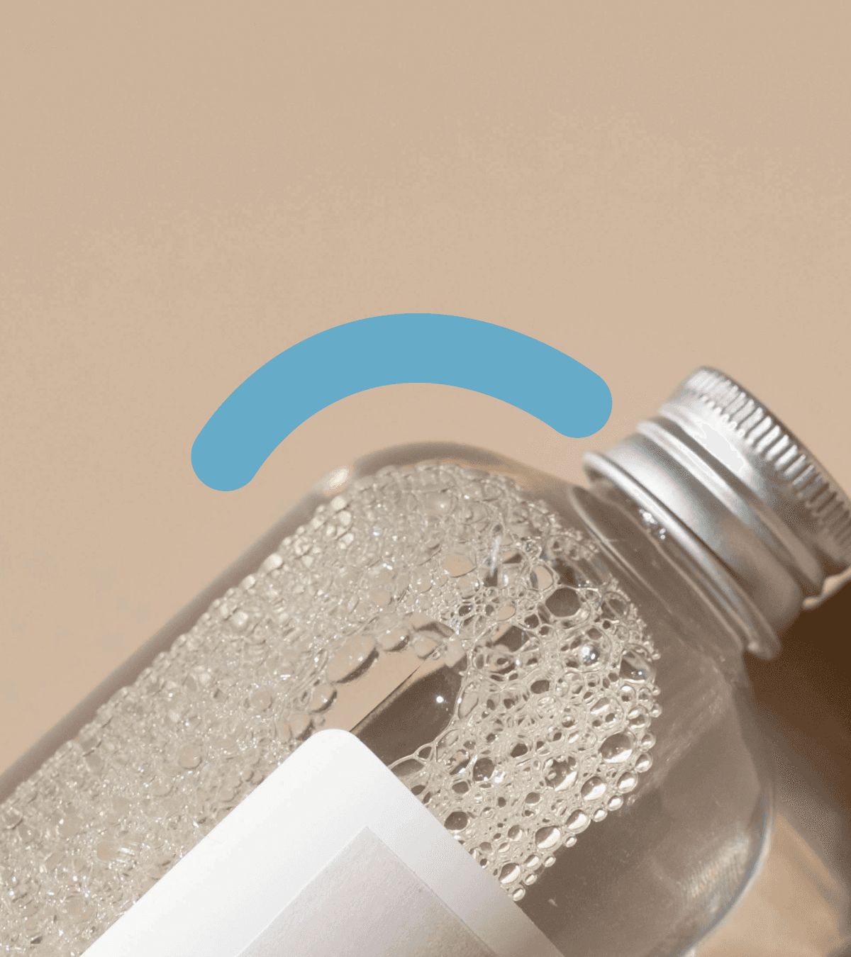 Image of a a transparent glass bottle with transparent liquid