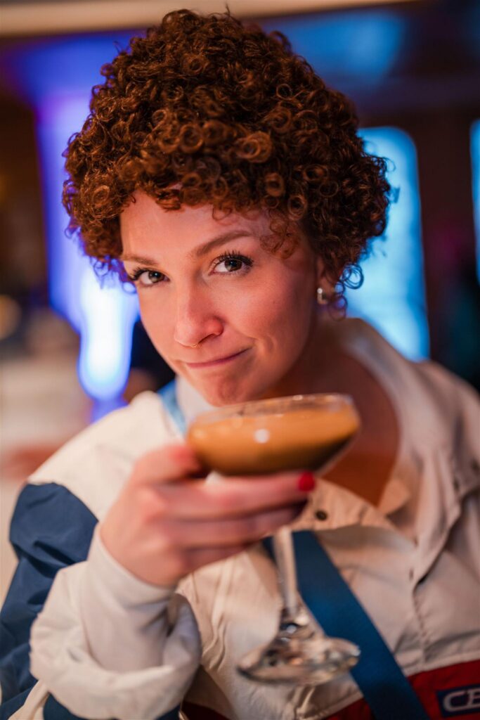 Event guest smiling while holding a cocktail