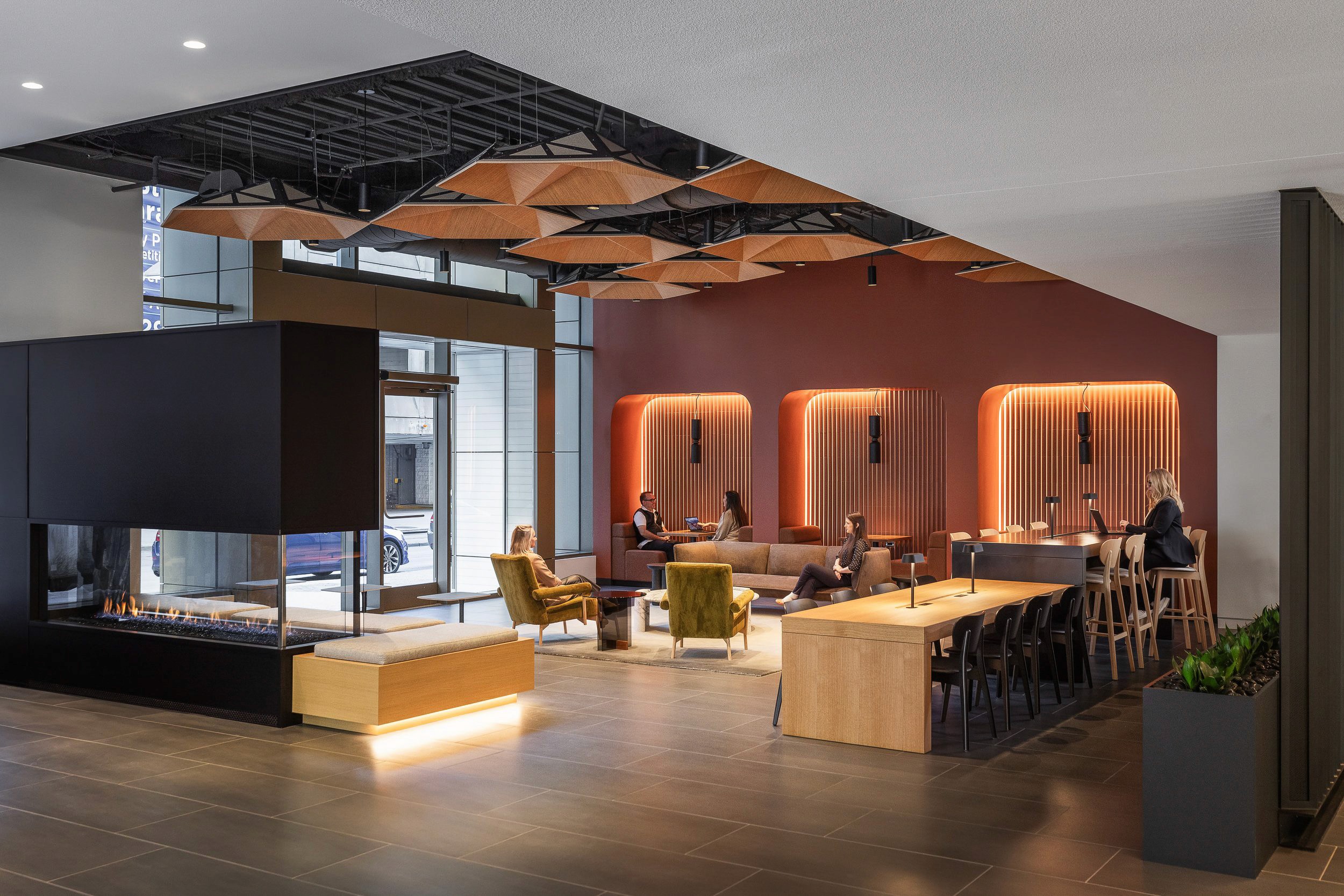 Modern lobby with fireplace, seating, and tables.
