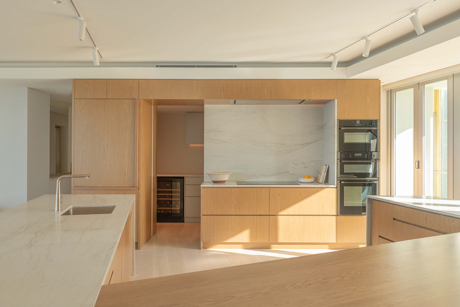 High Tide apartment kitchen with warm timber joinery, integrated appliances, and natural light overlooking Surfers Paradise coastline.