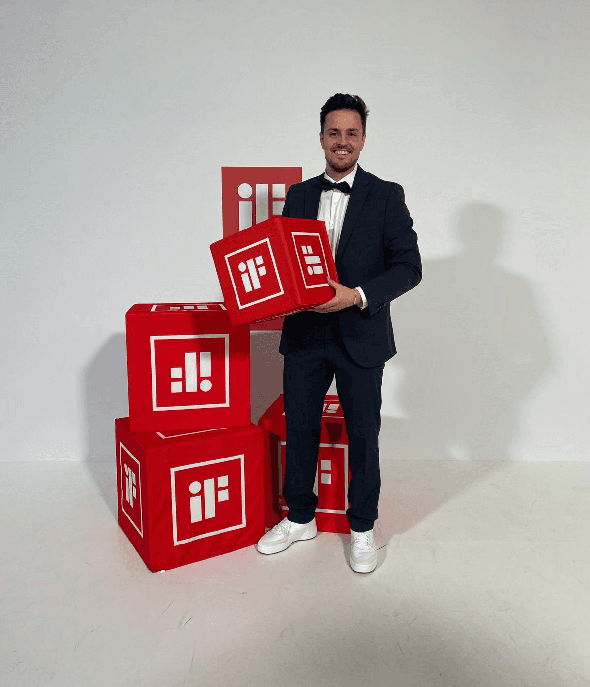 Man in suit holding a red cube with white if logo
