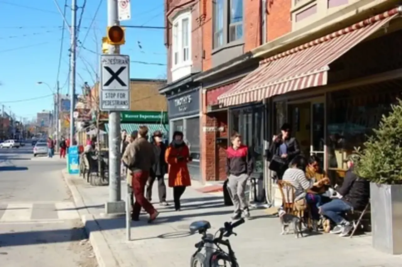 A busy street with coffee shops and a supermarket in Roncesvalles.