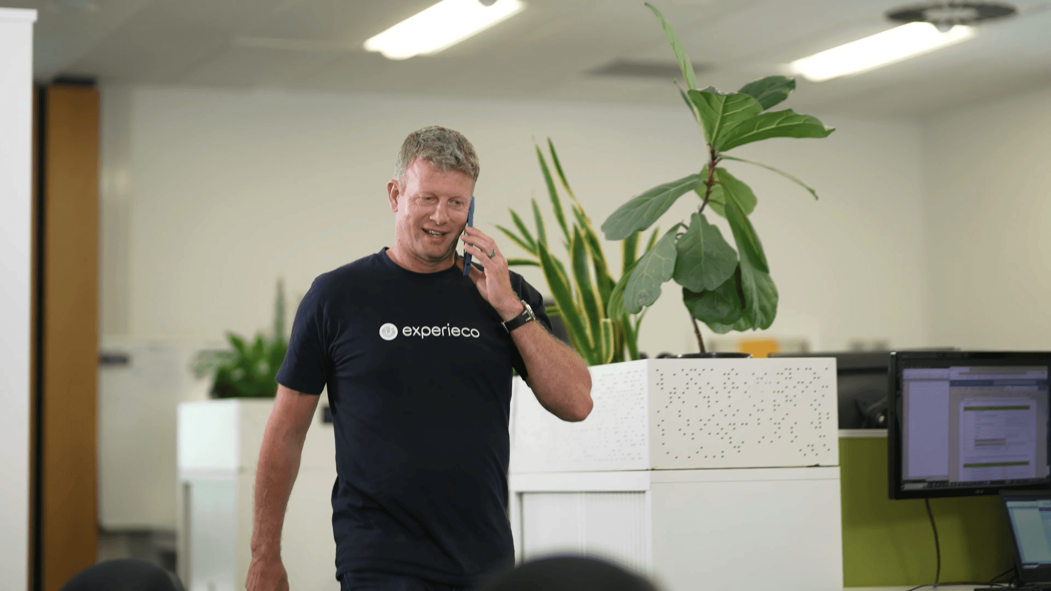 man in a red sweater working at the experieco office located in auckland new zealand