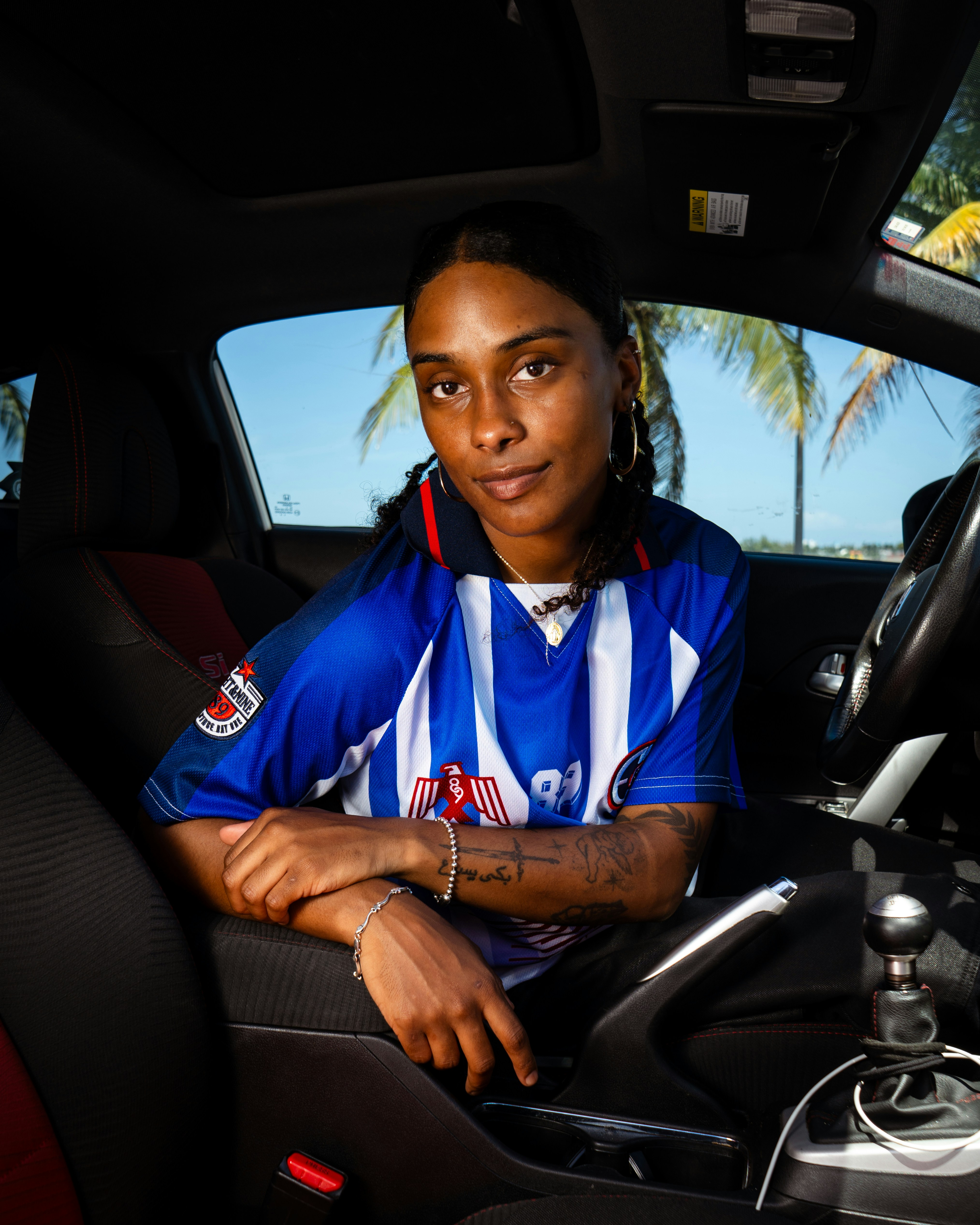 Woman in blue and white jersey sitting in car