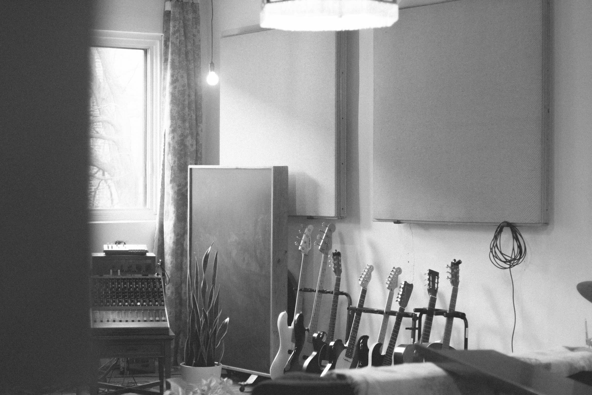 Studio de musique avec plusieurs guitares alignées contre un mur