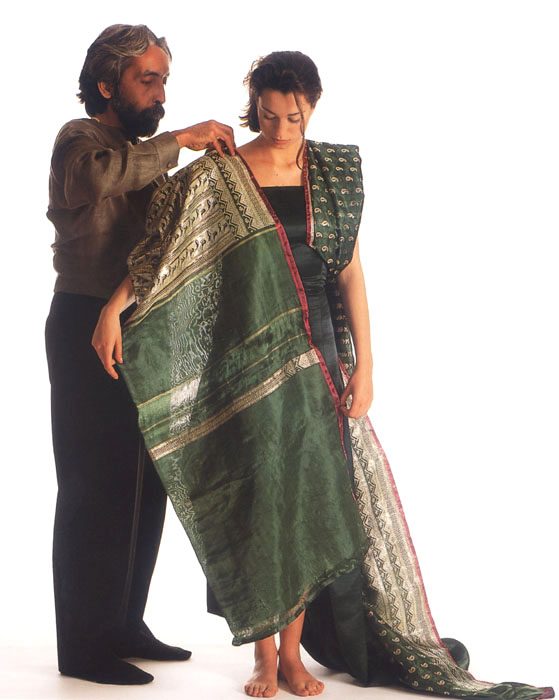 The artist fitting a garment on a model. Photograph.