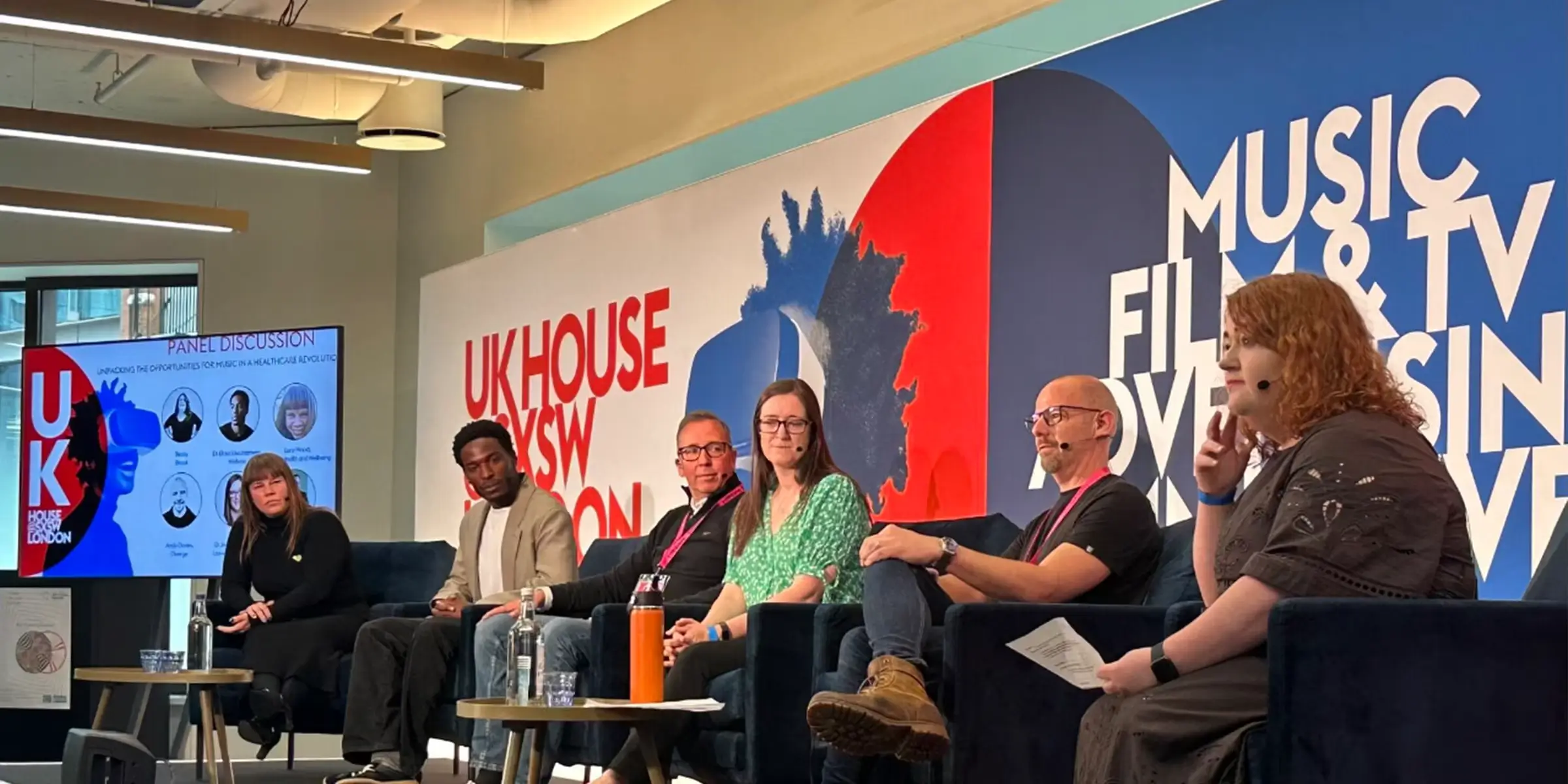 Panel discussion at UK House during SXSW London, featuring speakers from music, healthcare, and technology discussing innovation and wellbeing.