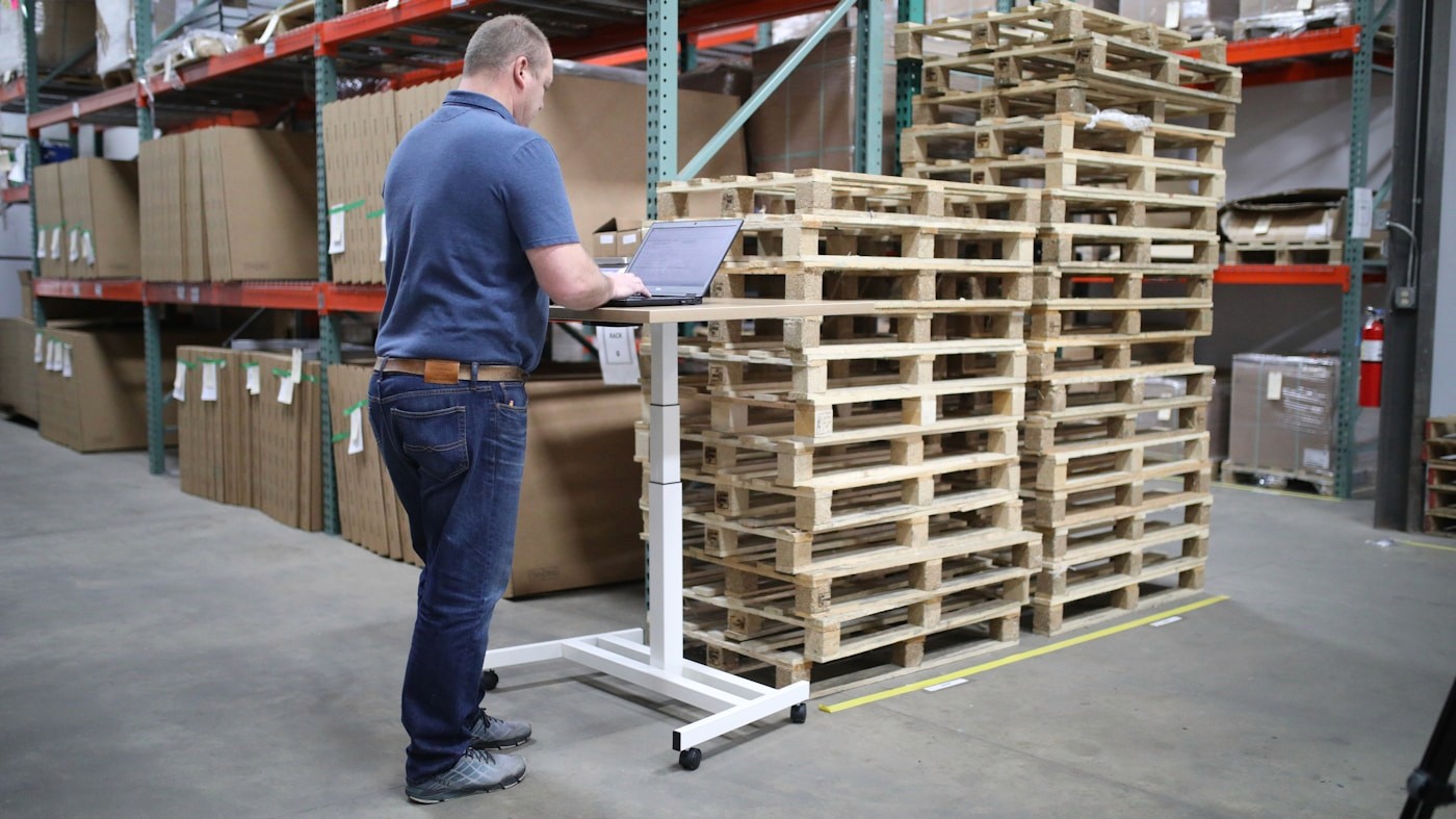 Warehouse operator working beside storage pallets