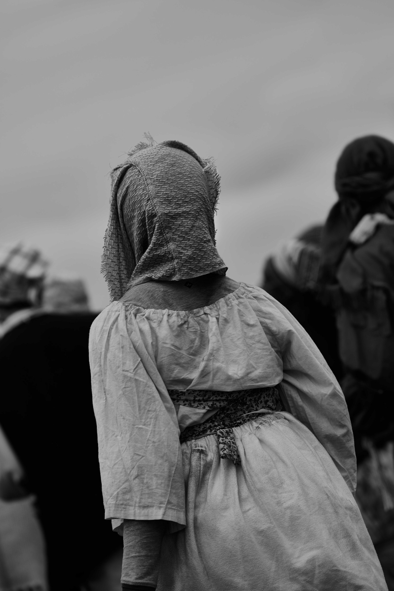 A photograph depicting an enslaved re-enactor from behind showcasing her costume, photographed during the Dread Scott recreation of the 1811 German coast uprising. 