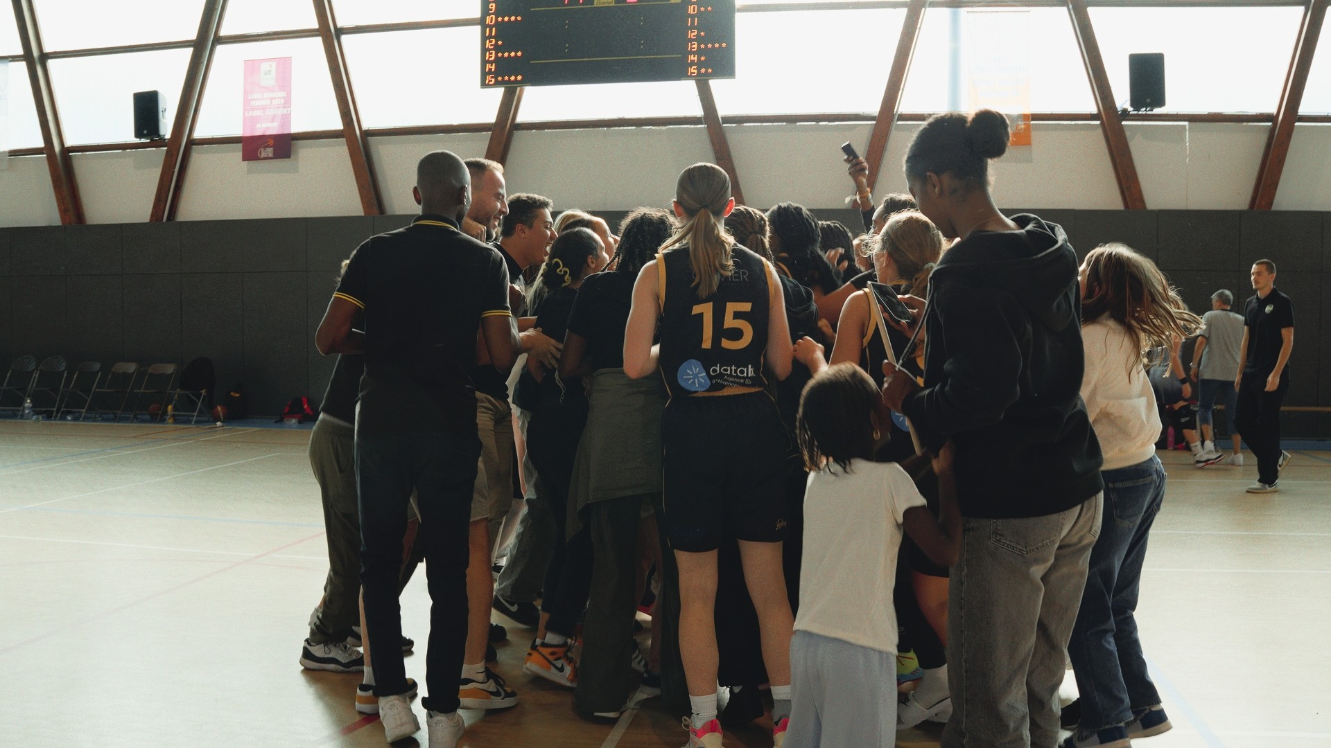 Célébration de la victoire finale des U15F du SOH, joueuses et supporters réunis sur le terrain.