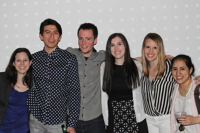 a group of five students with a grey background behind them