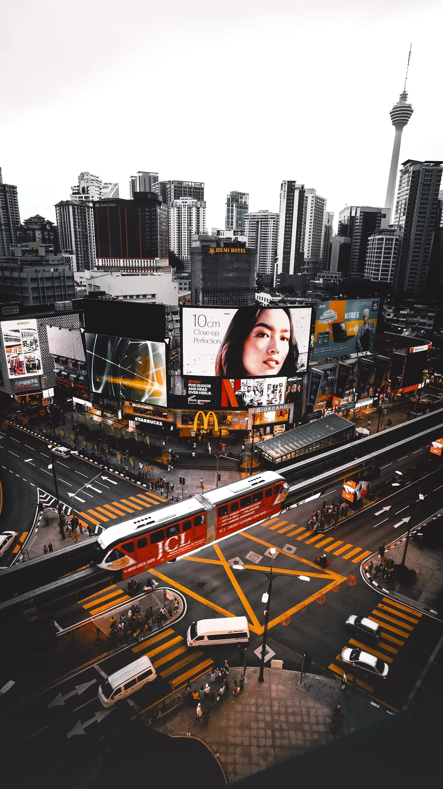 Busy urban intersection with large digital billboards and moving traffic, showcasing high-impact DOOH advertising in a city environment.