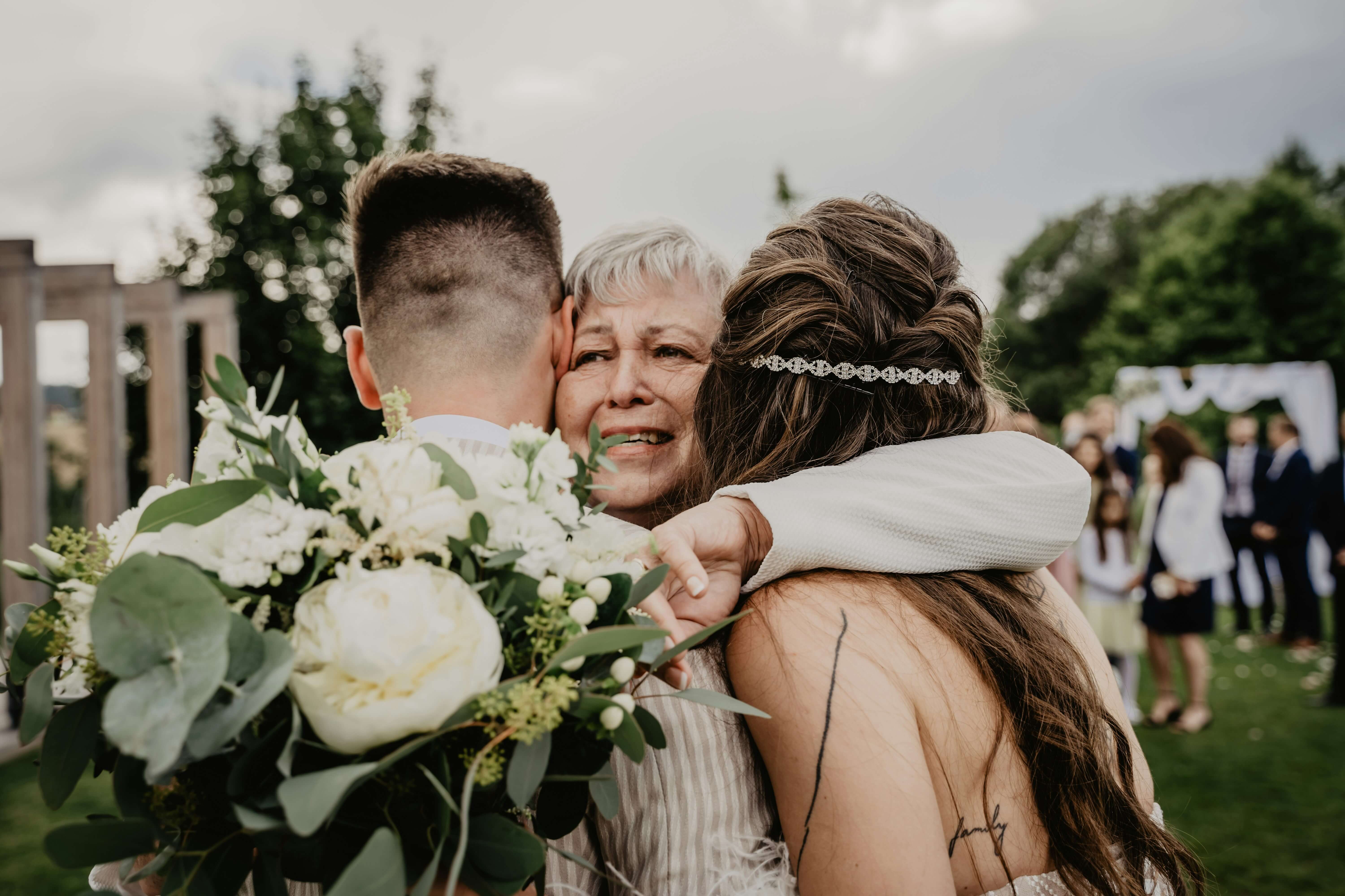 Motherly figure hugging couple
