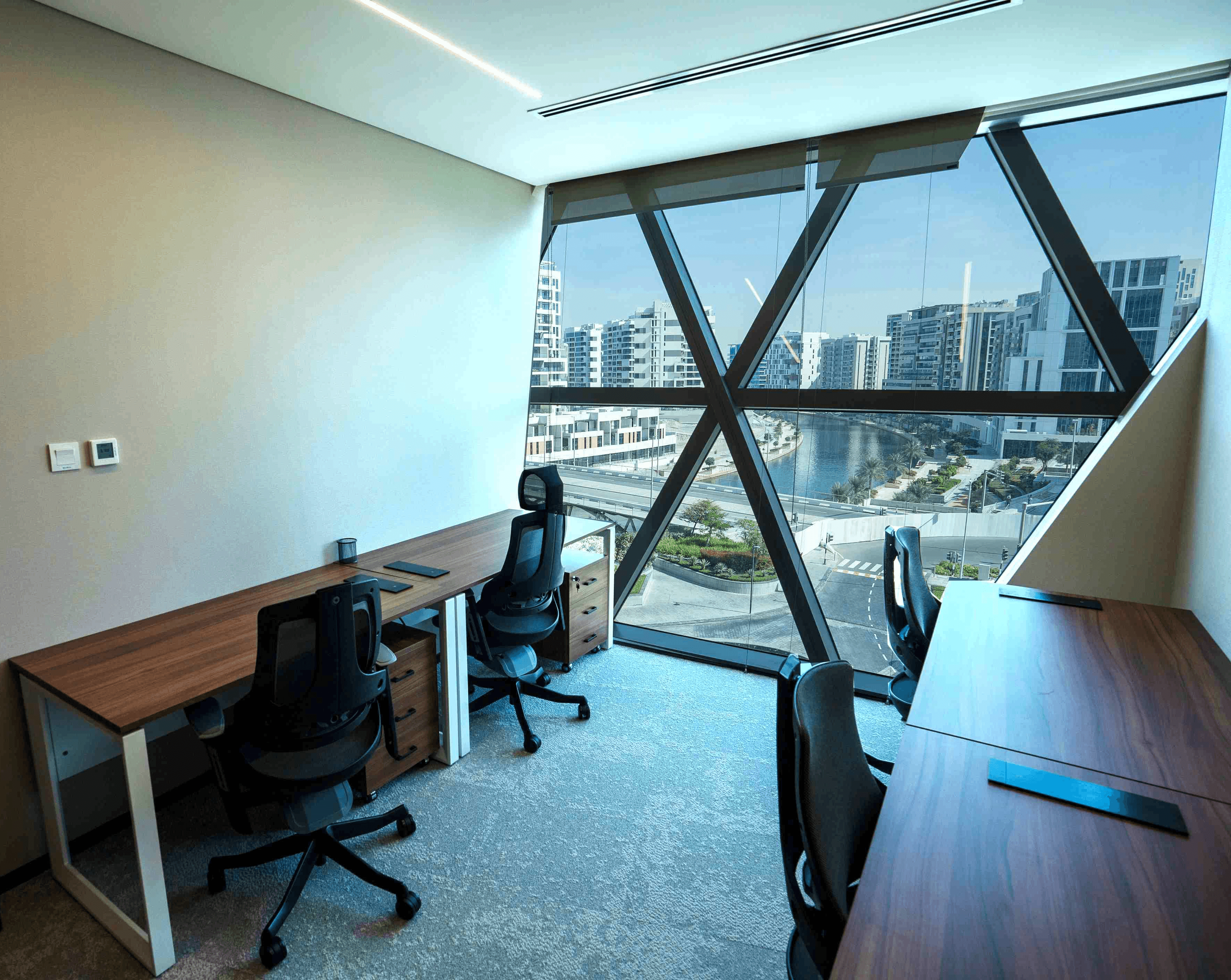 Coworking space at Aldar HQ with natural daylight, waterfront views, and executive desk setups.
