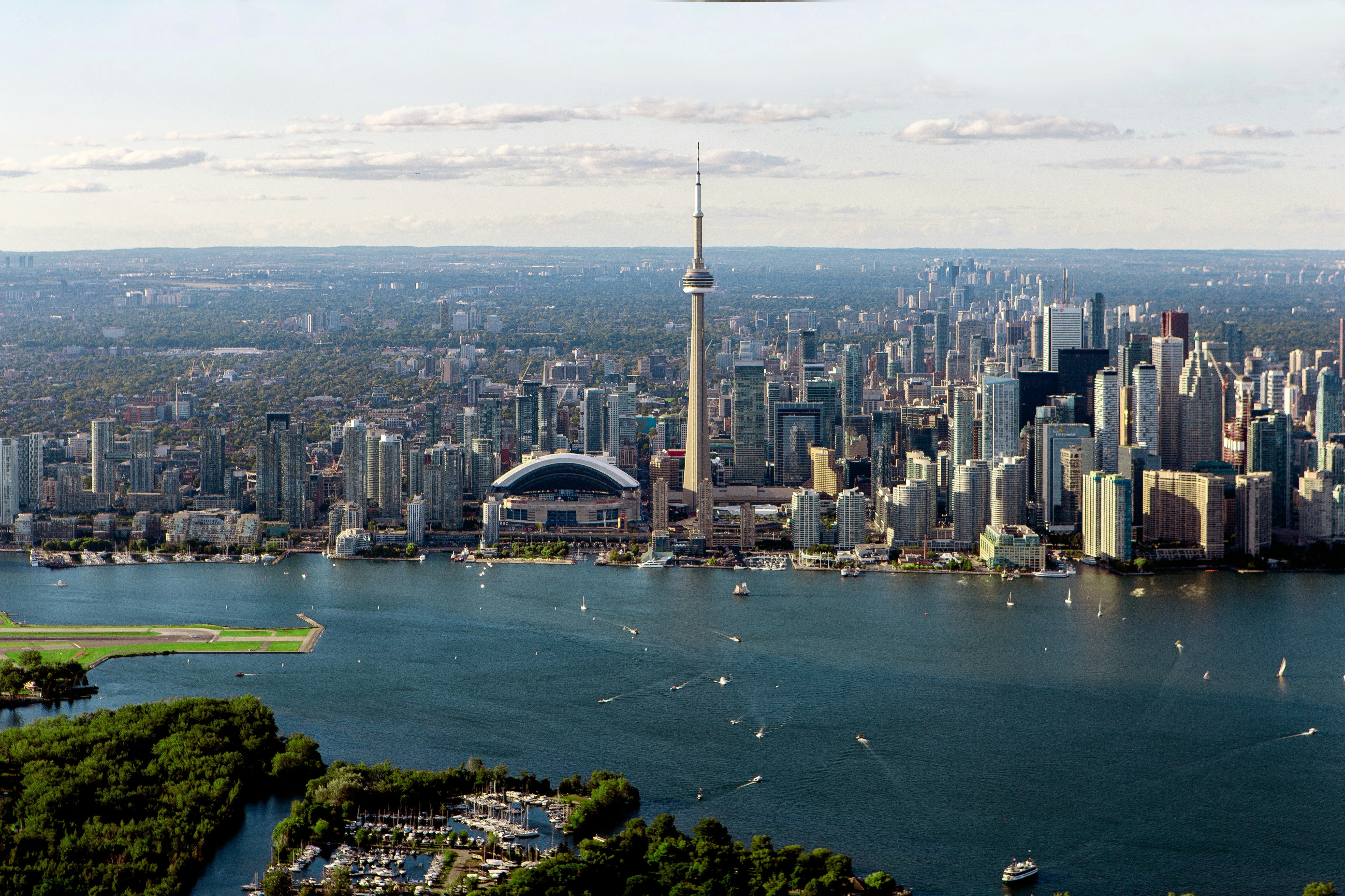 Vista aérea do centro de Toronto com a CN Tower e o lago Ontário ao fundo.
