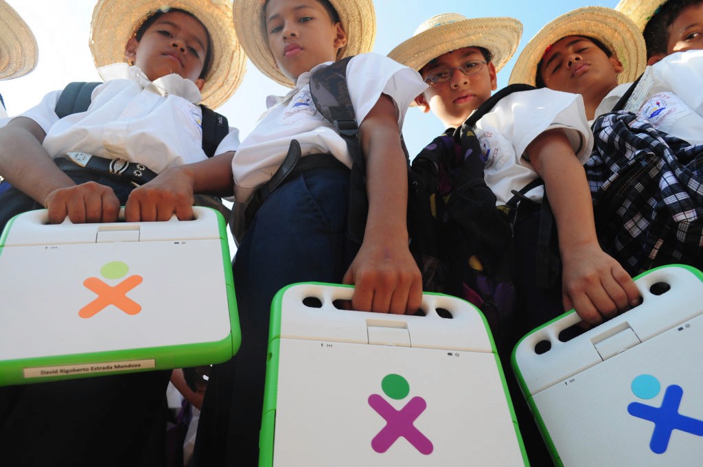 Children holding laptops by the handle.