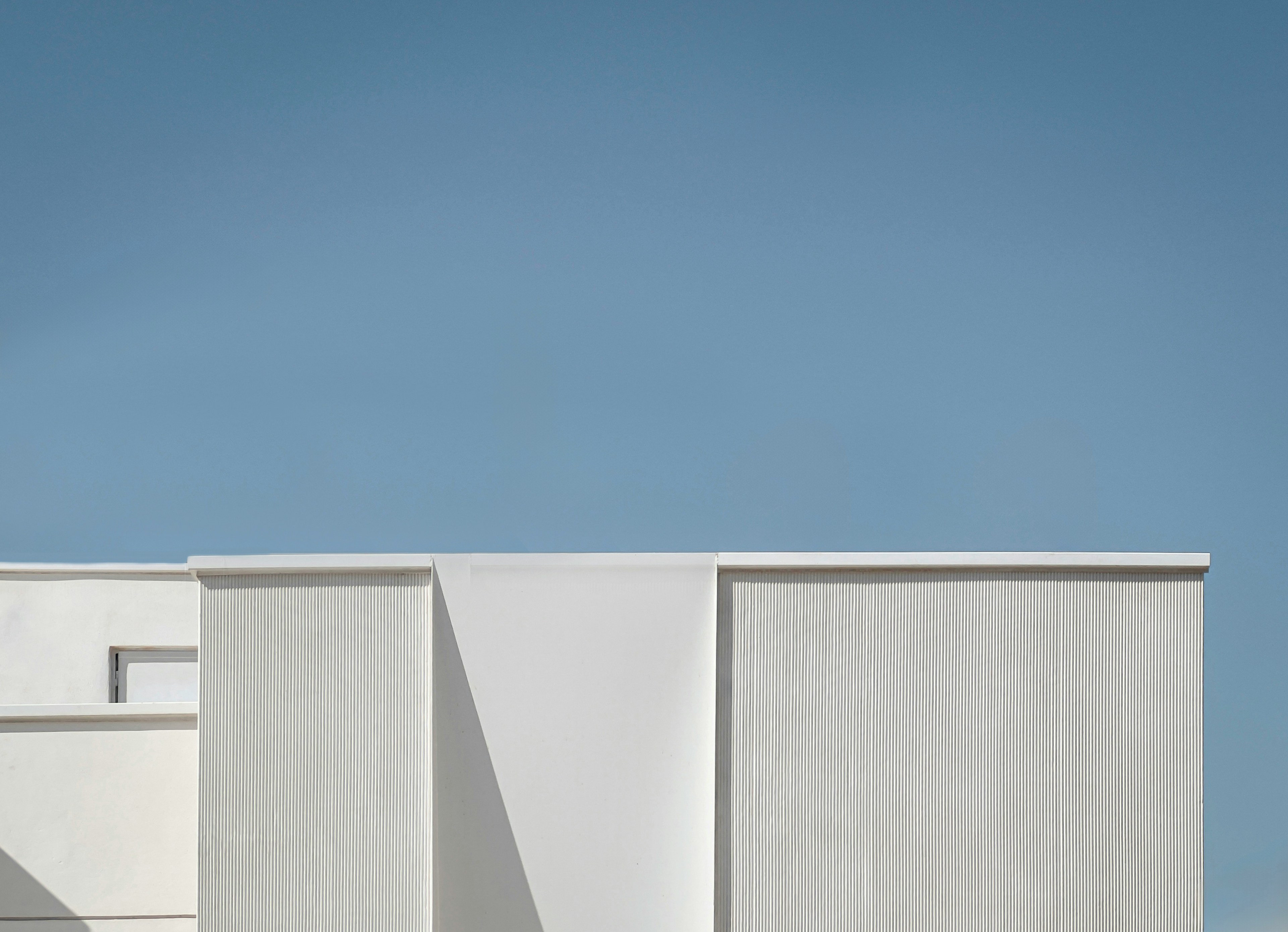 a tall white building with a clock on it's side