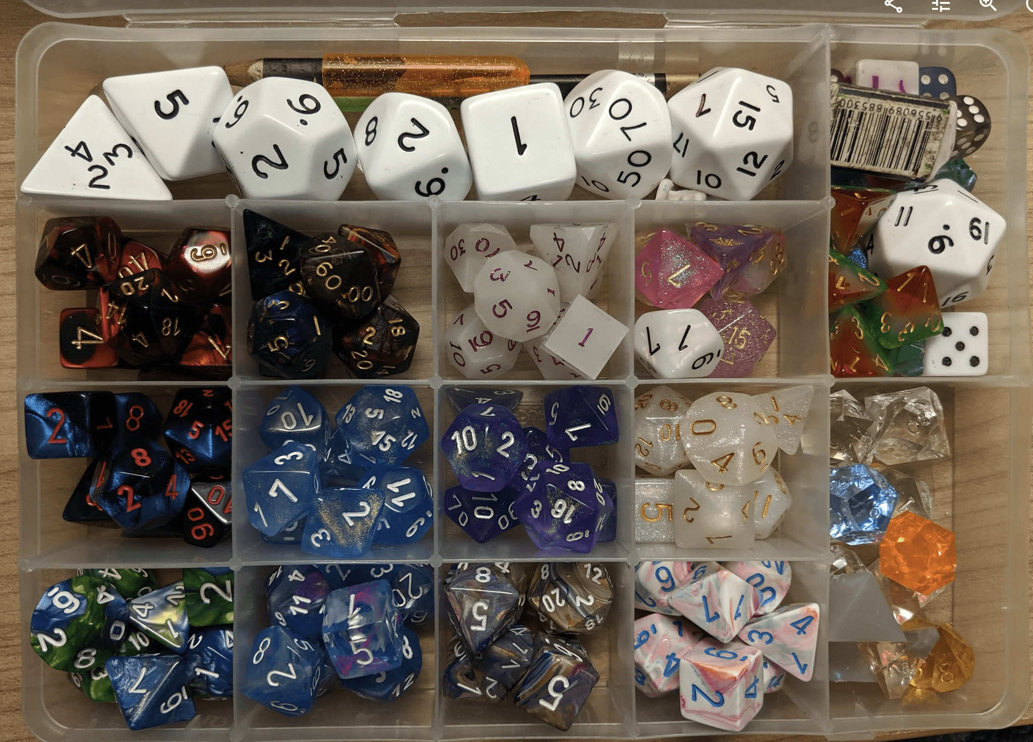 Top view photograph of a box of polyhedral role-playing dice. 