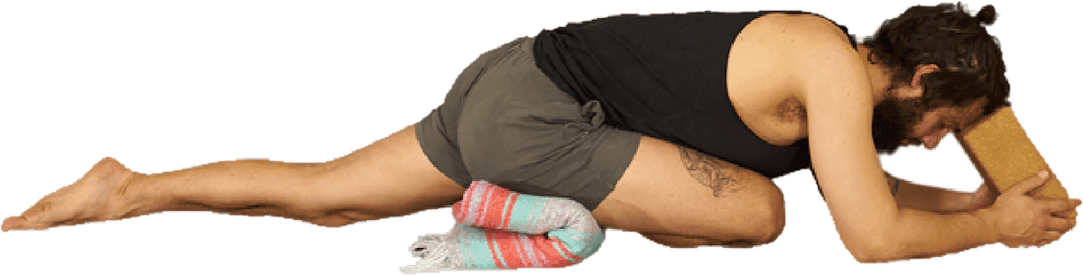 Pigeon Pose supported with a block placed under the hip of the front leg, so the pelvis stays level.