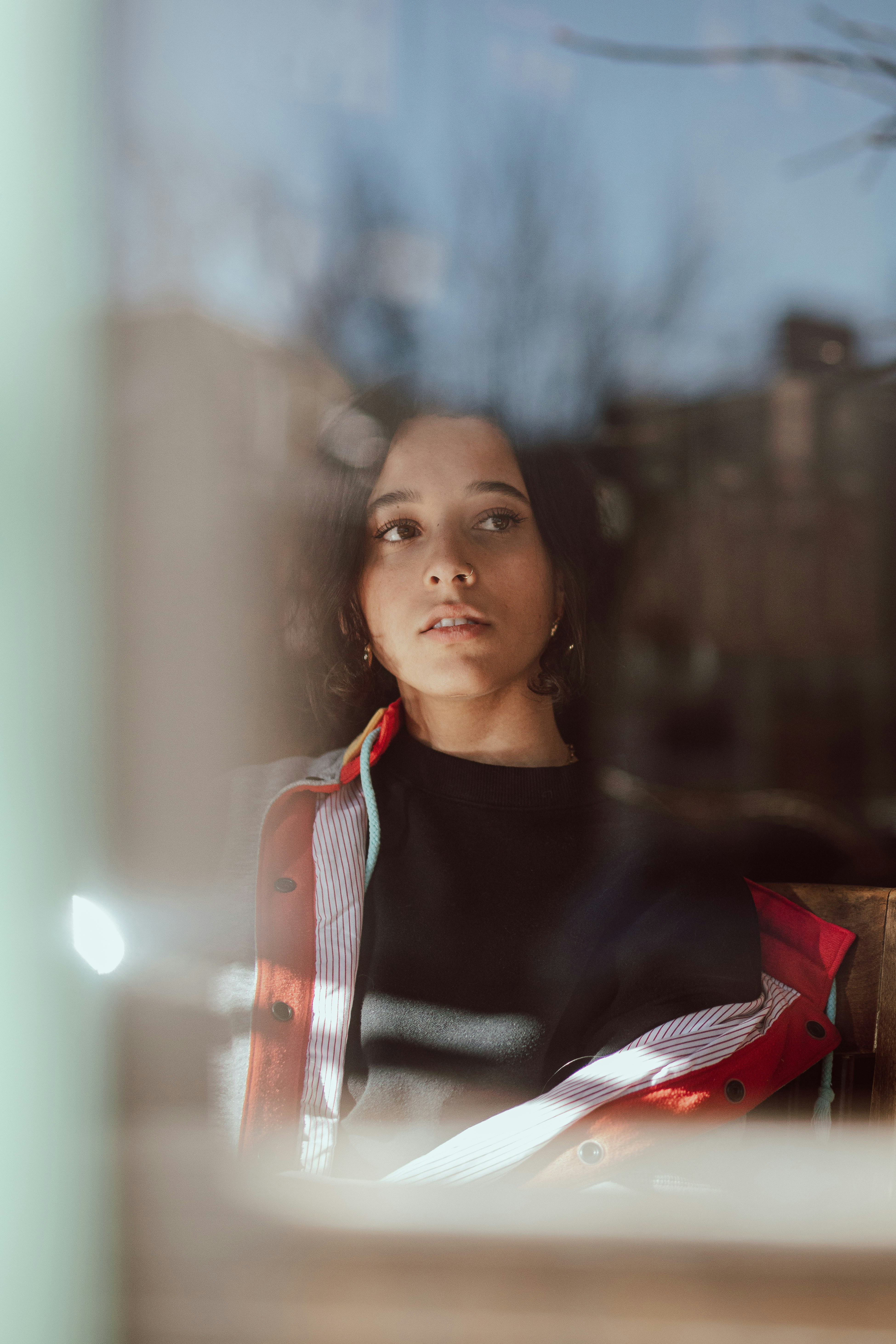 Young woman looking out a window thoughtfully
