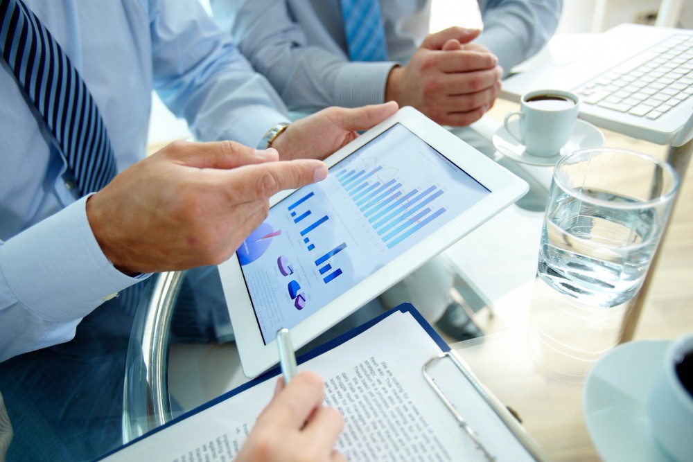 Two colleagues talking in a modern office hallway.