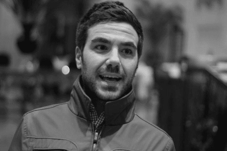Black and white portrait of a smiling person with curly hair