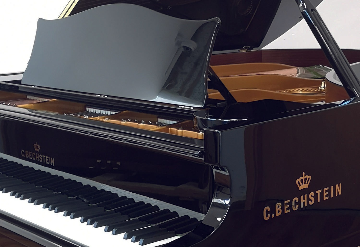 A side view of the glossy black C. Bechstein piano, emphasizing its polished finish and refined aesthetics.