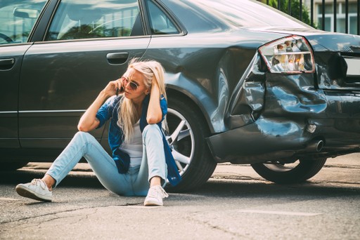 woman making a phone call after being involved in a car accident