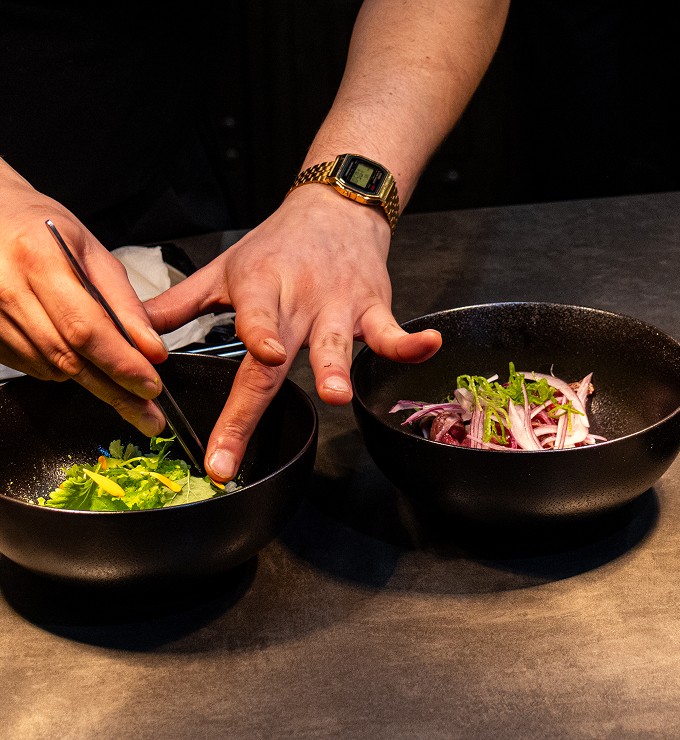 Ruce šéfkuchaře při finálním servírování pokrmu