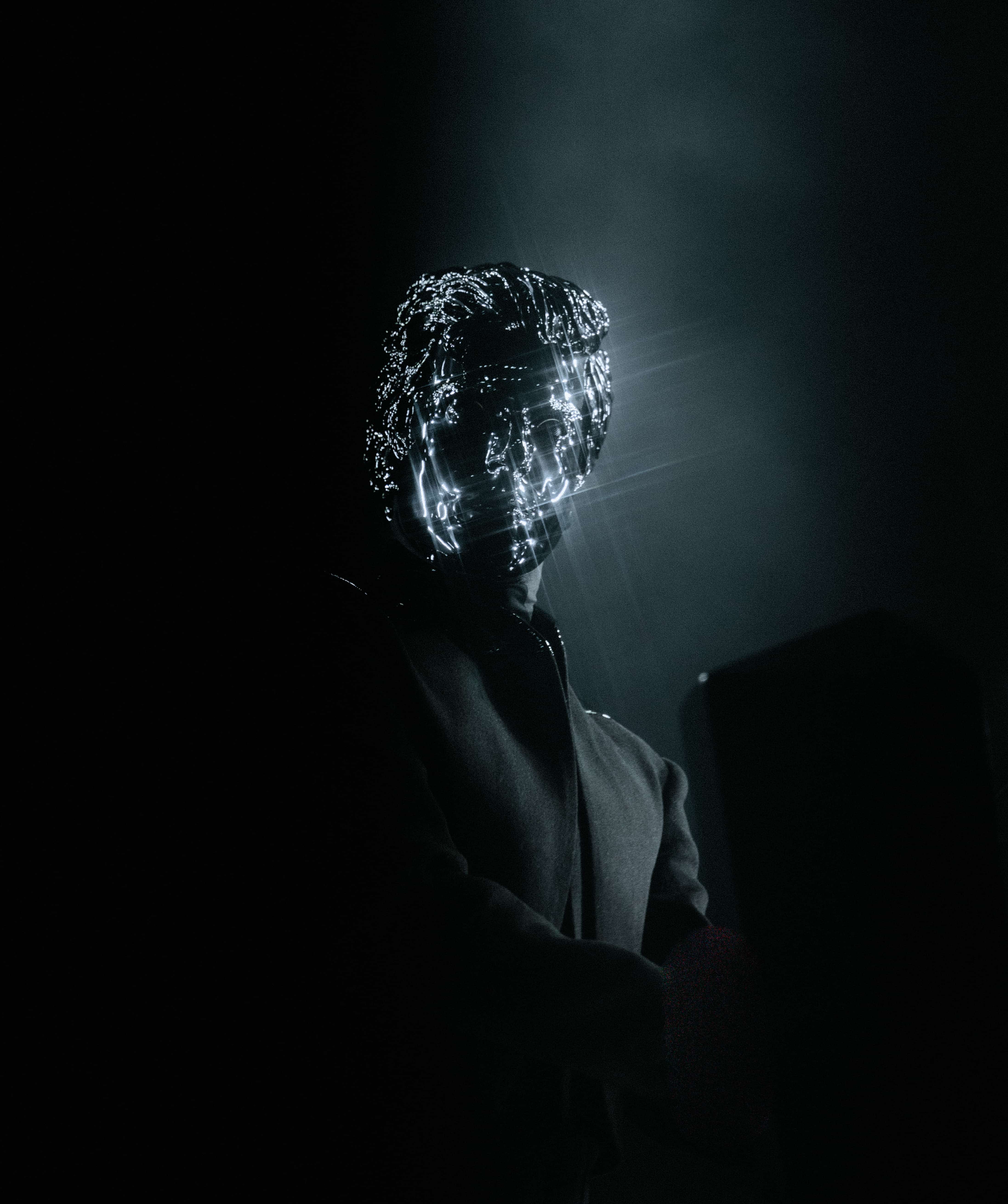 Gesaffelstein performing at Coachella 2024 wearing reflective mask with dramatic lighting, captured by A World Away creative director Brandon Densley
