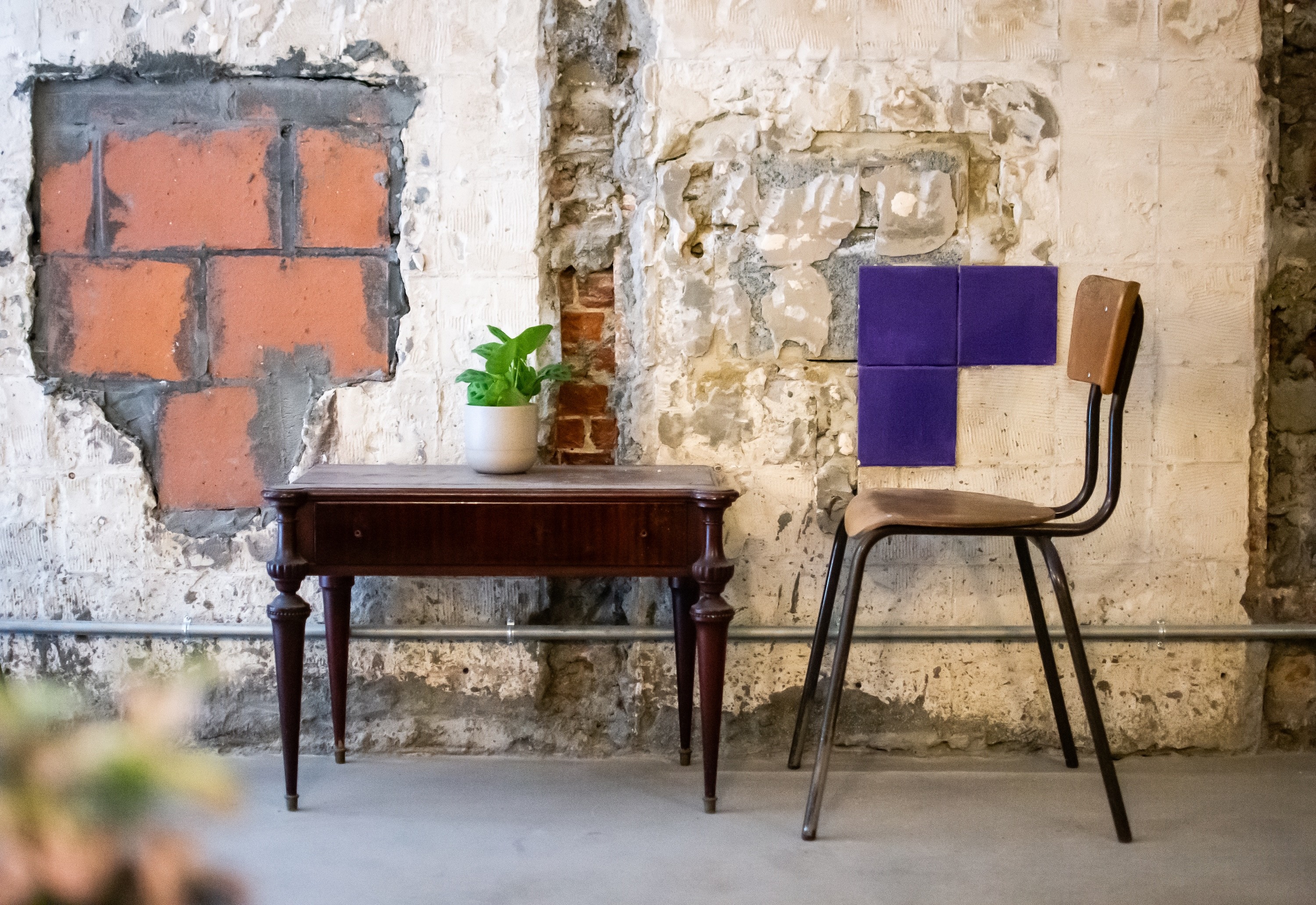 Table and chair with purple tiles at a bar